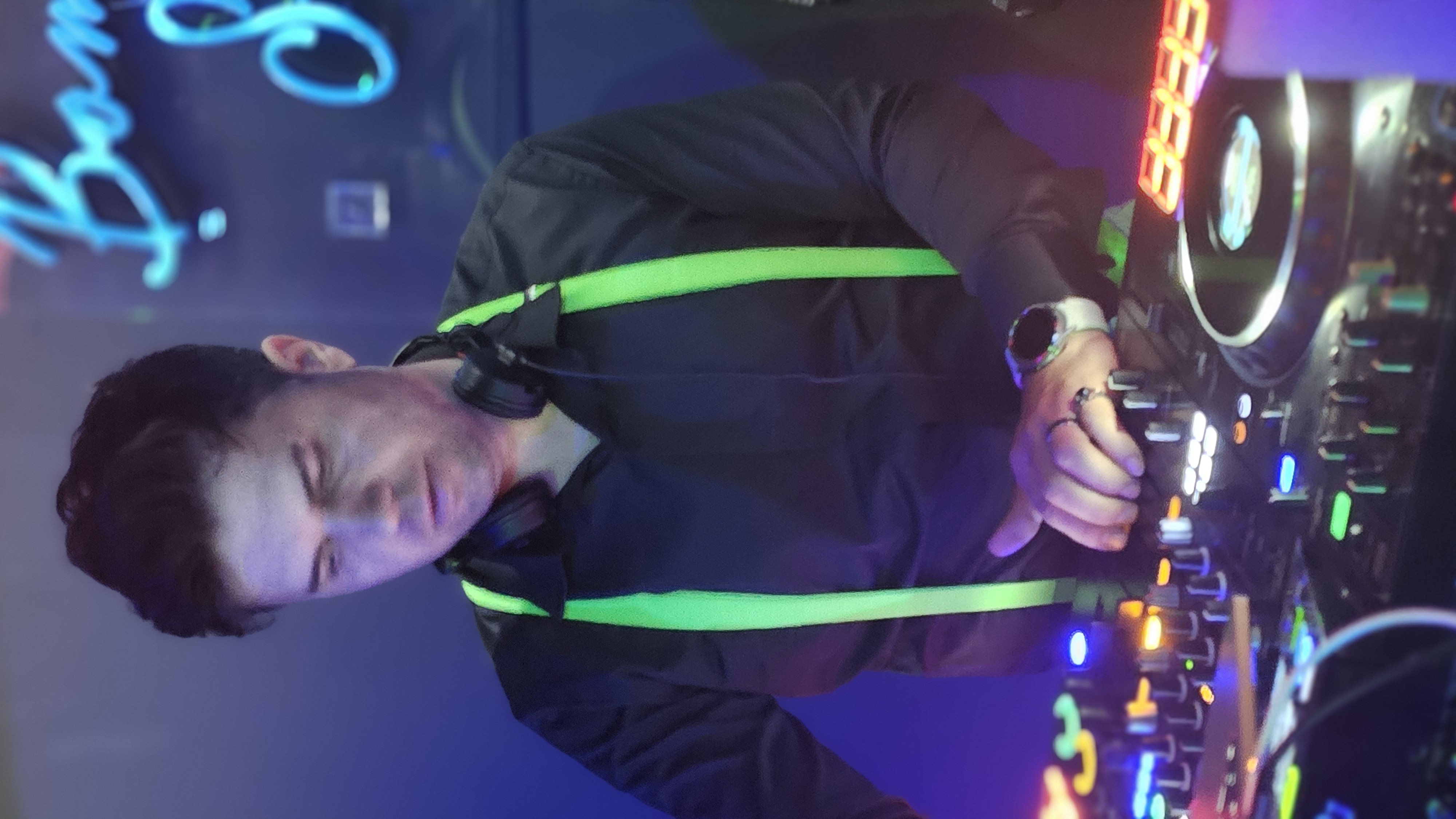DJ Optimum an den Decks, neon-grüne Hosenträger